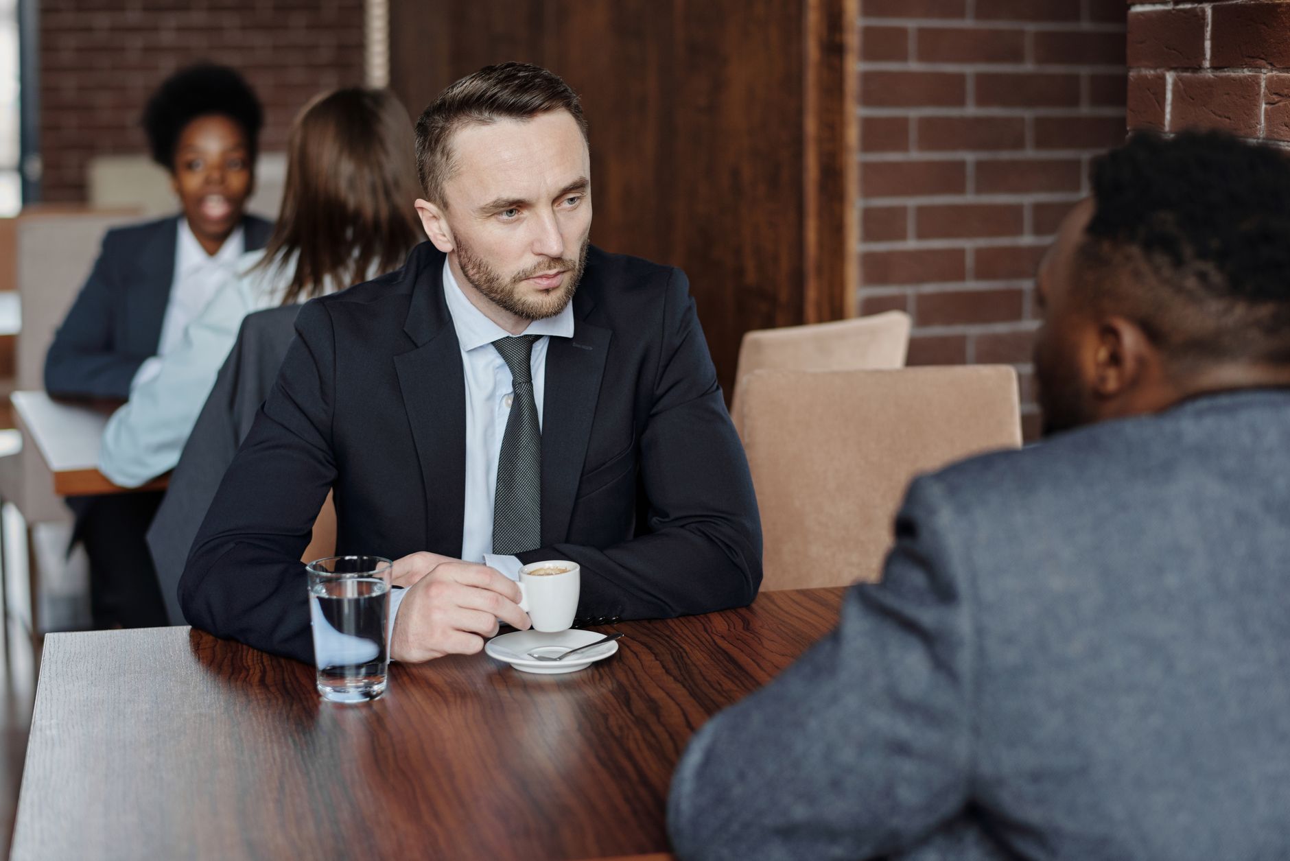Two people talking across a table, broking as an ongoing relationship rather than one transaction