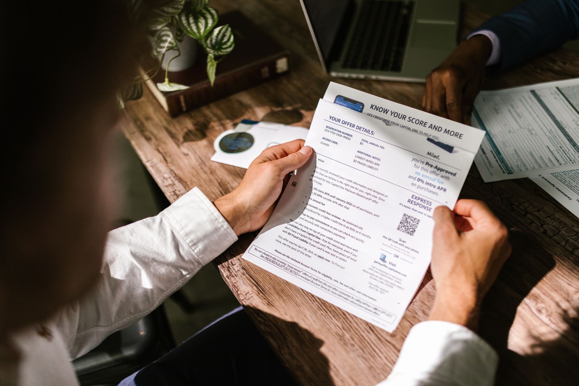 Reading a credit report at a desk, the character and capacity checks behind a loan decision