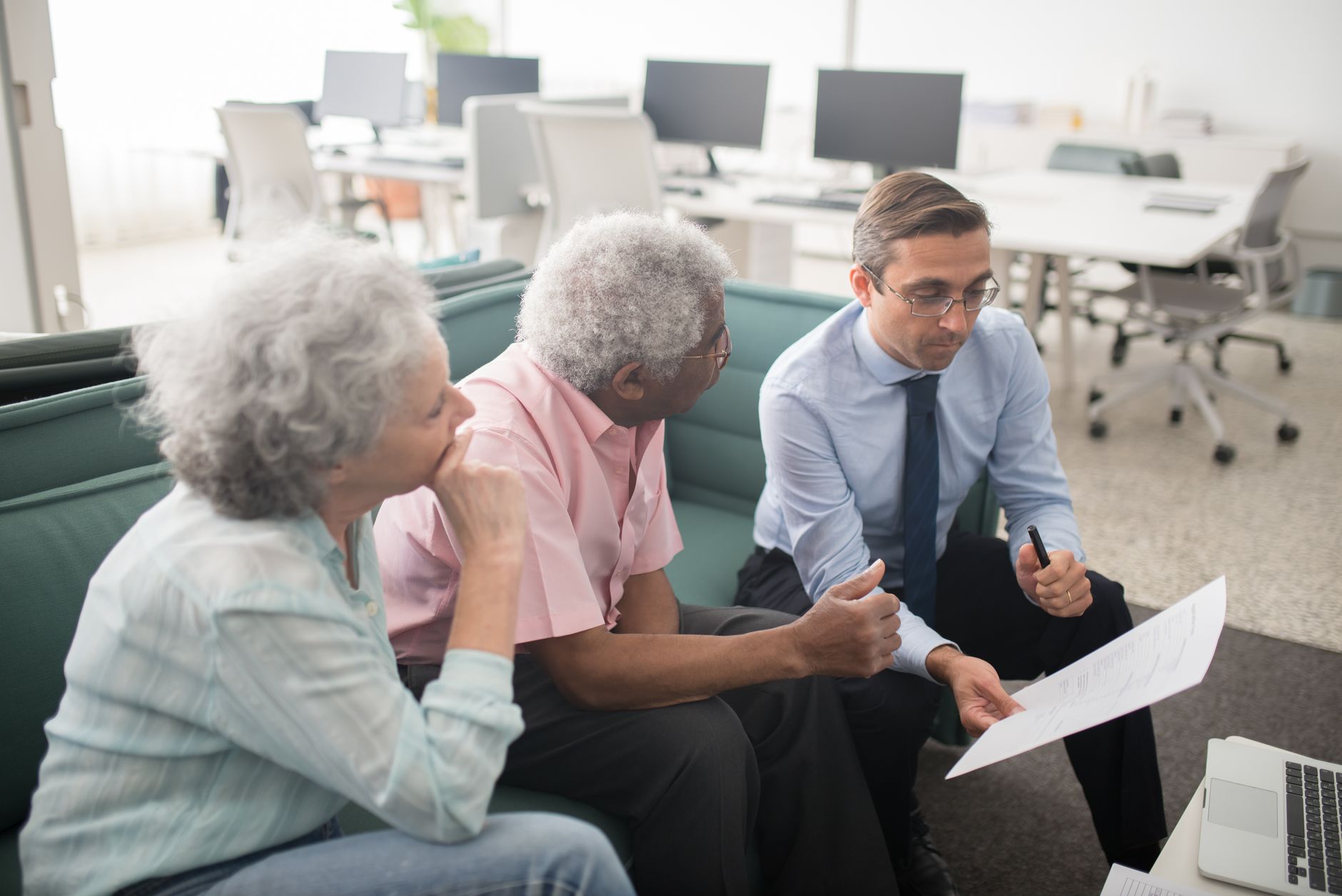 A broker talking a couple through their home loan options across a panel of lenders